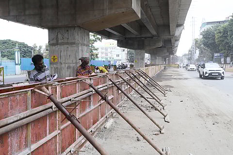 Highway department workers engaged in building walls away from the pillars at Saibaba Colony, thereby decreasing the motorable space and width of the Mettupalayam Road in Coimbatore on Saturday.