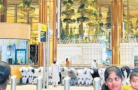A screengrab of the video shows a group of passengers offering namaz at Terminal 2 of Kempegowda International Airport on Monday.