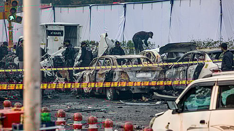 Charred remains of vehicles at a cordoned off area following a blast that occurred near Red Fort Metro Station on Monday.