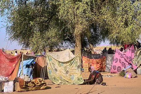 A Sudanese who fled el-Fasher city, after Sudan's paramilitary forces killed hundreds of people in the western Darfur region, ties her tent at her camp in Tawila, Sudan, Sunday, Nov. 2, 2025. 