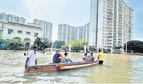 Residents wading through the severely waterlogged Semmancheri and DLF City regions of Chennai during the 2021 floods.