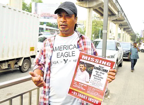 With a poster of his missing father Suraj Lama  near the Pathadipalam metro station 