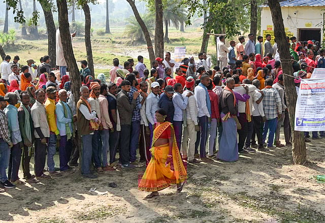 People wait in queues before casting their votes during the second and final phase of the Bihar Assembly elections, in Gaya Ji, Tuesday, Nov. 11, 2025. 