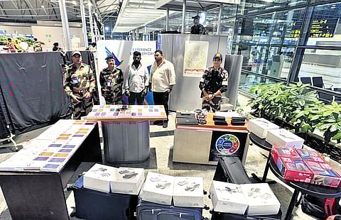 CISF personnel display the seized Apple products and drones, worth `1.4 crore, at the Rajiv Gandhi International Airport, Shamshabad, Hyderabad, on Wednesday