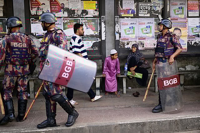 Security personnel walk past a bus stop as ousted Prime Minister Sheikh Hasina and her former ruling Awami League party called for a nationwide "lockdown" in protest against her trial, in Dhaka, Bangladesh, Thursday, Nov. 13, 2025. 