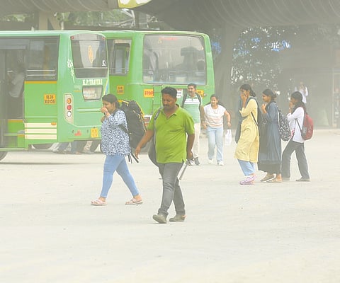 Passengers struggle to walk through a cloud of dust at Vyttila Mobility Hub in Kochi.