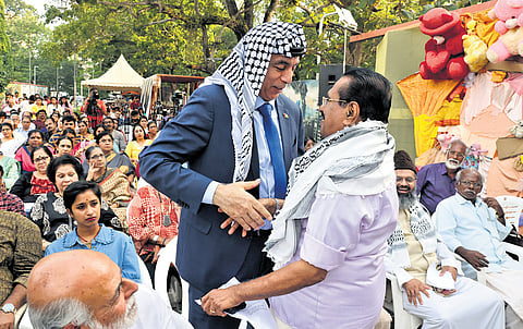 Writer George Onakkoor greets Palestinian Ambassador to India Abdullah Abu Shawesh during a Palestine solidarity meet at Manaveeyam Veedhi in Thiruvananthapuram on Sunday.