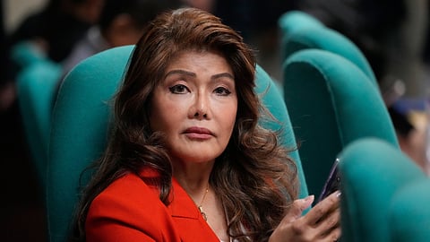 Senator Imee Marcos checks her phone during a break at a Senate hearing in Manila, Philippines, on March 20, 2025.