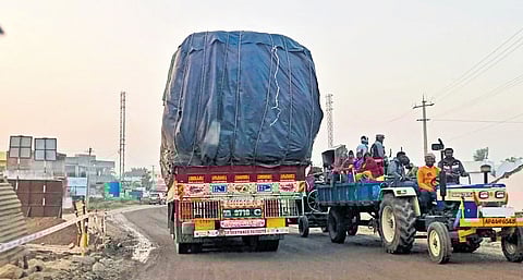 A truck passes next to a tractor on a narrow stretch of NH-563 on Wednesday 