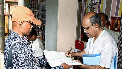 A Booth Level Officer (BLO) interacts with a resident during the house-to-house distribution of Enumeration Forms (EFs) for the second phase of the Special Intensive Revision (SIR) of electoral rolls at Baghajatin in Kolkata.
