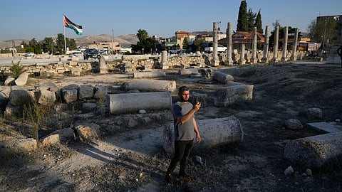 A Palestinian visitor takes a photo at the Roman historical site in the West Bank town of Sebastia on Thursday, Nov. 20, 2025.