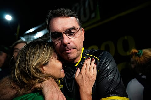Flavio Bolsonaro, son of ex-President Jair Bolsonaro, hugs a supporter during a vigil outside the former president's residence.
