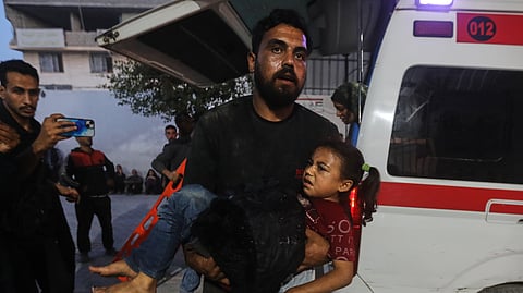 A Palestinian man carries a wounded girl into al-Shifa Hospital following Israeli strikes on the Gaza Strip, Saturday, Nov. 22, 2025. 