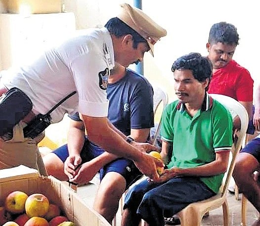 Traffic police distribute fruits to physically challenged people.