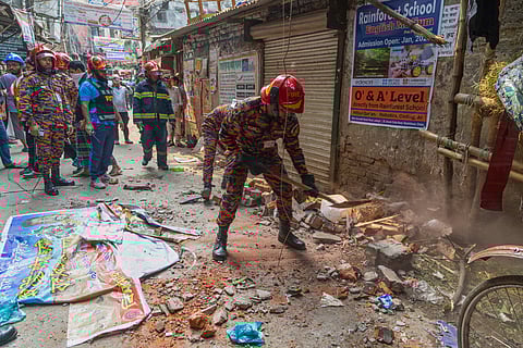 A rescue official clears the debris from roof and wall collapse after an earthquake in Dhaka, Bangladesh, Friday, Nov. 21, 2025. 