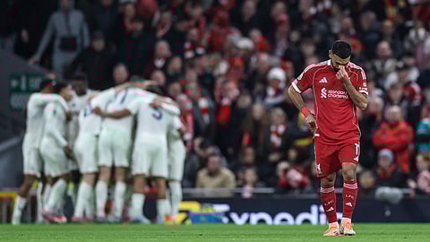 Liverpool's Egyptian striker #11 Mohamed Salah (R) reacts as Nottingham Forrest players (back L) celebrate after their third goal during the English Premier League football match between Liverpool and Nottingham Forest at Anfield in Liverpool, north west England on November 22, 2025. 