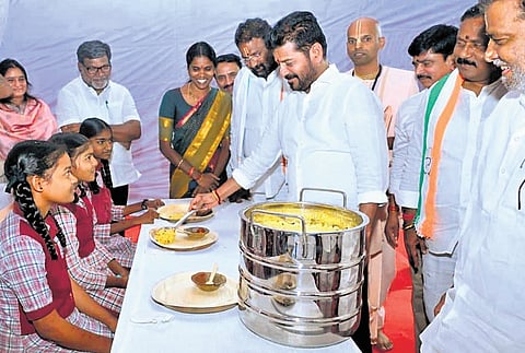 Chief Minister A Revanth Reddy serves food to the students at during the bhumi Puja ceremony of Akshaya Patra Foundations upcoming Centralised Kitchen in Kodangal
