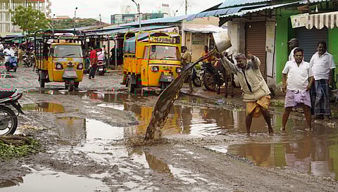 Traders at the Mattuthavani vegetable market manually clear water that stagnated inside the facility on Monday.