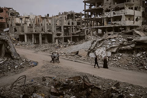 Palestinian children stand outside the partially damaged Al-Mushtal Sports Club in Gaza City on November 26, 2025.