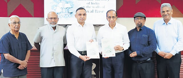 Cochin Shipyard CMD Madhu S Nair handing over the brochure of the mural project taken up by the Better Kochi Response Group to Commodore V Z Job