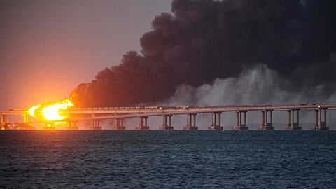FILE - Flame and smoke rise from Crimean Bridge connecting Russian mainland and Crimean peninsula over the Kerch Strait, in Kerch, Crimea, on Oct. 8, 2022.