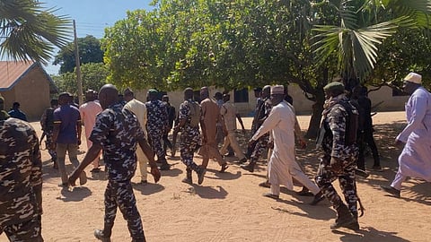 Police and government officials walk past St. Mary's Catholic Primary and Secondary School where gunmen on Friday abducted children and staff in Papiri community, Nigeria, Tuesday, Nov.25, 2025.