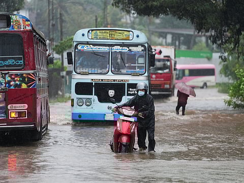 A man wades through floodwater outside his house following heavy rainfall in Kaduwela on the outskirts of Colombo on Friday.