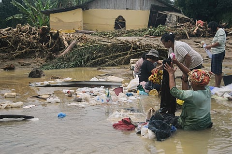 Rescuers recover the body of a flood victim in Padang Panjang, West Sumatra, Indonesia, Monday, Dec. 1, 2025. 