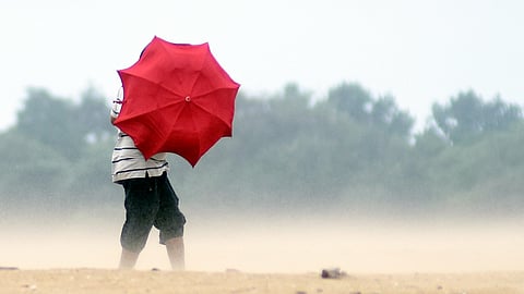 People seen taking a cover after strong winds blow on the shores at Foreshore Estate beach on Sunday following the cyclone Ditwah