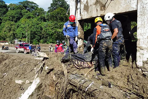 Rescuers recover the body of a flood victim in Padang Panjang, West Sumatra, Indonesia, Monday, Dec. 1, 2025. 