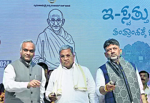CM Siddaramaiah, flanked by IT-BT Minister Priyank Kharge and Deputy CM DK Shivakumar, launches e-Swathu 2.0 in Bengaluru on Monday. 