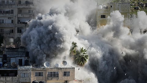 Smoke rises as Israeli forces demolish the home of Abdul Karim Sanoubar, a suspected Palestinian militant who has been accused by Israel of planting bombs on buses in central Israel, in Nablus, West Bank, Tuesday, Dec. 2, 2025.