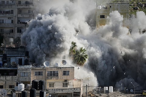 Smoke rises as Israeli forces demolish the home of Abdul Karim Sanoubar, a suspected Palestinian militant who has been accused by Israel of planting bombs on buses in central Israel, in Nablus, West Bank, Tuesday, Dec. 2, 2025