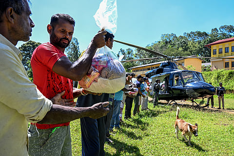 Volunteers help unload dry rations from a helicopter to marooned residents in Nuwara Eliya, 100 kilometres east of Colombo. (Photo | AFP)