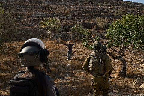 Smoke rises as Israeli forces demolish the home of Abdul Karim Sanoubar, a suspected Palestinian militant who has been accused by Israel of planting bombs on buses in central Israel, in Nablus, West Bank, Tuesday, Dec. 2, 2025.