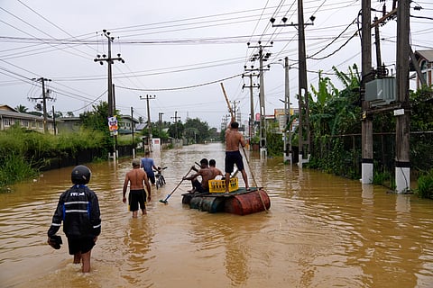 People use a crude raft to navigate a flooded street in Colombo, Sri Lanka, Saturday, Nov. 29, 2025.