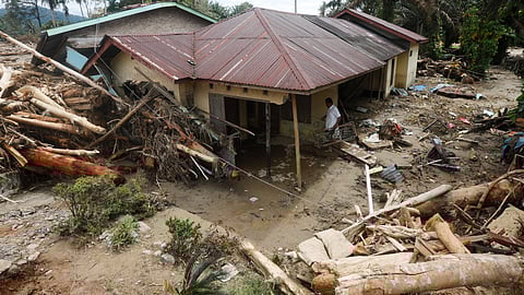 A man cleans his house at a village affected by flood in Batang Toru, North Sumatra, Indonesia, Wednesday, Dec. 3, 2025.