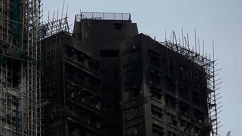 Charred remains of bamboo scaffolding can be seen in the aftermath of a deadly fire that started Wednesday at Wang Fuk Court, a residential estate in the Tai Po district of Hong Kong's New Territories, Tuesday, Dec. 2, 2025.