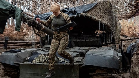 A Ukrainian soldier from the Khartia brigade, callsign Muza, jumps down from a tank following a demonstration for The Associated Press, Thursday, Nov. 6, 2025, in Kharkiv Oblast, Ukraine.