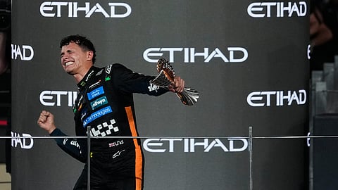 McLaren’s British driver Lando Norris celebrates after finishing the race third to win the world championship title at the end of the Abu Dhabi Formula One Grand Prix at the Yas Marina Circuit in Abu Dhabi on December 7, 2025.