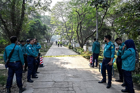 Police personnel stand guard at the Martyred Intellectuals Memorial in Dhaka on December 7, 2025.