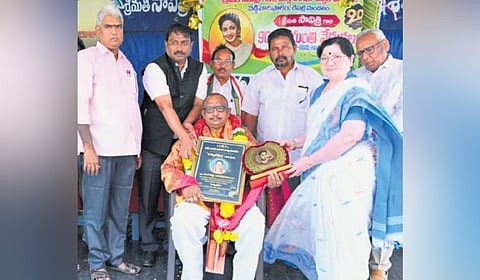 Rangishetti Ramesh Babu receiving the prestigious title ‘Vishwabharana.’ 