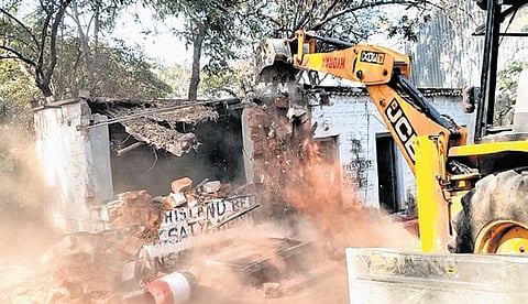 An earthmover is pressed into razing illegal structures in Miyapur on Monday