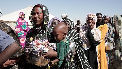 Women displaced from El-Fasher stand in line to receive food aid at the newly established El-Afadh camp in Al Dabbah, in Sudan's Northern State, Nov. 16, 2025.