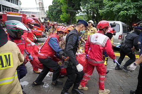 Rescuers carry out the body of a victim from the site of a fire in Jakarta, Indonesia, Tuesday, Dec. 9, 2025.