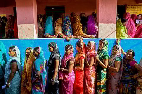 Female voters stand in queues to cast their ballots at a polling station in Bihar on November 6, 2025