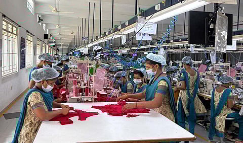 Workers engaged in production at a private knitwear manufacturing company in Tiruppur.