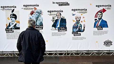 A visitor looks at a political billboard displayed at the Atreju festival, an annual event organised by the youth wing of the Italian far-right party Fratelli d'Italia (Brothers of Italy), in central Rome on December 7, 2025.