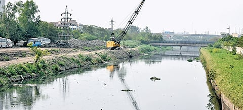Workers cleaning drain filled with plastic and muck in New Delhi.