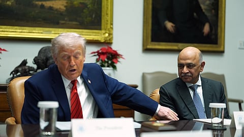 US President Donald Trump lays a hand on CEO of IBM Arvind Krishna during a roundtable meeting with business leaders in the Roosevelt Room of the White House, Wednesday, Dec. 10, 2025, in Washington.